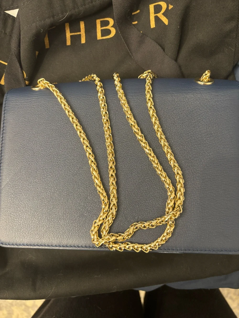 Strathberry blue, cream, and tan crossbody bag with gold hardware